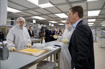 Rep. Greg Stanton tours the solar power manufacturing facilities of space startup Solestial. From left, Module Process Technicians Anthony Lebario and Luis Acre-Romero present Rep. Stanton with a solar power module to sign.