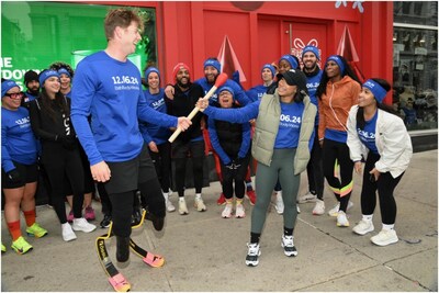 American gold medalist Hunter Woodhall passes the torch to gold medalist Jordan Chiles in front of Bath & Body Works’ scented holiday billboard at 433 Broadway in NYC. Hunter and Jordan, along with gold medalist Tara Davis-Woodhall,  participated in a fun run through the streets of Manhattan, culminating in the lighting of a giant countdown candle in Hudson Yards to help brand fans count down the moments to the official start of Candle Day sales!