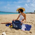 Unwinding on the beach with essentials tucked into a chic C'est La Vie Paris tote.