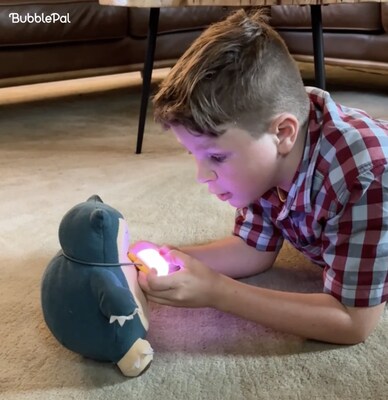 Child using Bubble Pal with his stuffed animal