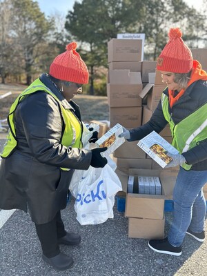 Stephanie Edwards, associate human resources generalist, Smithfield Foods, and Melissa Williams, digital learning designer, Smithfield Foods, pack bags with holiday food items donated by Kroger for Smithfield’s Holiday Meal Distribution event in Smithfield, Virginia.