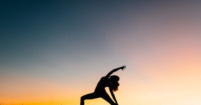 Silhouette of a female practicing outdoors with a colorful sky in background