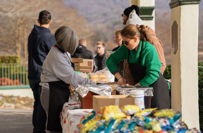 Image is of volunteers distributing brisket to residents at Christmas for Chimney Rock.