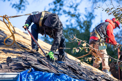 A skilled crew member from Quality Roofing Solutions meticulously removing old roofing materials during a residential roof replacement. The process, known as a roof tear-off, involves stripping away existing shingles, underlayment, and other components to expose the roof deck, ensuring a solid foundation for the new installation.