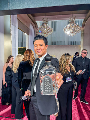 Mario Lopez holding a bottle of Casa México Tequila Cristalino on the red carpet at the 82nd Golden Globes, surrounded by event attendees. (Photo courtesy of Rodney Rinks)