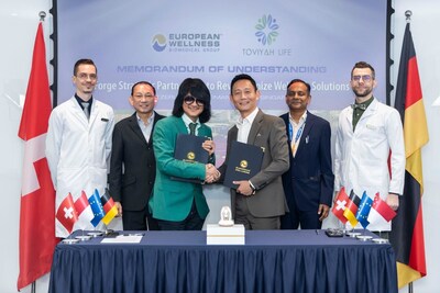 Prof. Dato' Sri Dr. Mike Chan and Kevin Chua exchange MOU signings, marking a significant partnership between European Wellness Biomedical Group and Toviyah Life Pte Ltd. This collaboration aims to revolutionize wellness solutions.