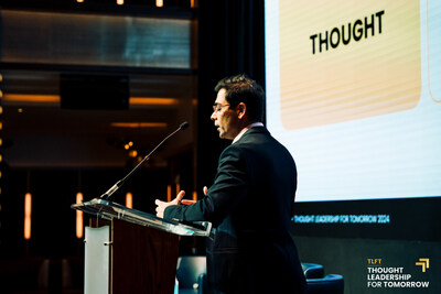 iResearch Services' CEO Yogesh Shah, speaking at the 2024 Thought Leadership for Tomorrow event, presenting insights on stage with a large screen behind him.