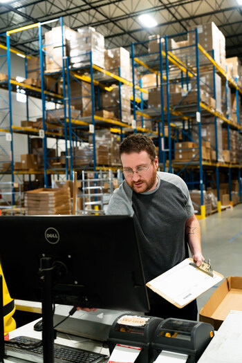 An associate at the distribution center prepares customer orders for final shipment.