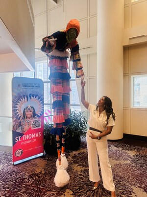 Deputy Commissioner RoseAnne Farrington shares a moment with a Moko Jumbie during Caribbean Week in New York City.