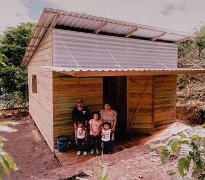 A Honduran family in front of their new house, which Crimson Cup team members helped to build.