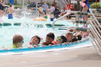Young swimmers practice kicking during the World's Largest Swimming Lesson at Rock River Rapids Aquatic Park in Derby, Kansas. The event teaches children key water safety skills to help prevent childhood drowning, the leading cause of death for kids ages 1-4 in the United States.