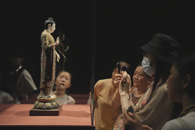 Photo shows that visitors gather around and enjoy the wonderful exhibits of Dehua white porcelain.