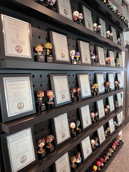 Cognizant’s AI Lab displays 59 patents, with space for the 23 pending patents. The Lab celebrates each inventor with a U.S. Patent plaque and a FunkoPop figurine of their choice. Cognizant’s AI Lab displays 59 patents, with space for the 23 pending patents. The Lab celebrates each inventor with a U.S. Patent plaque and a FunkoPop figurine of their choice.