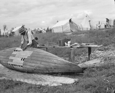 Innu qui répare un canot, 1948. Archives nationales à Québec, fonds Ministère de la Culture et des Communications. Photo : Jacques Claveau. (Groupe CNW/Bibliothèque et Archives nationales du Québec)