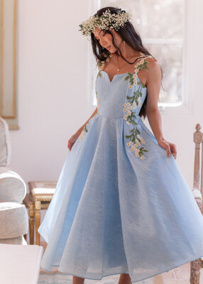 The Lily Petal Dress — sky-blue lace with cascading florals and a sweeping skirt. A timeless favorite made for elegance, grace, and unforgettable moments.