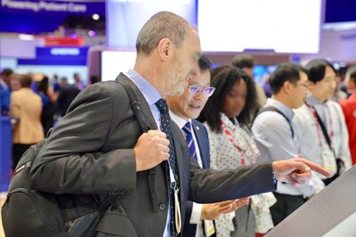 [Foto 2] Um participante assiste a uma apresentação sobre a STAgora? no estande da Seegene na ADLM 2025, em Chicago.