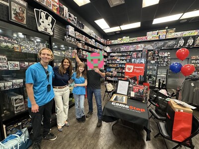 CMN Hospitals’ President and CEO, Aimee J. Daily, Ph.D., alongside the mystery auction winner and former national CMN Hospitals champion Nellie and family, posing with the infamous stapler at the GameStop event.