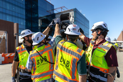 A group of construction workers high-fiving on the jobsite.