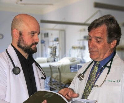Dr. Kenneth L. Scott, right, consults with a colleague regarding a patient's care.