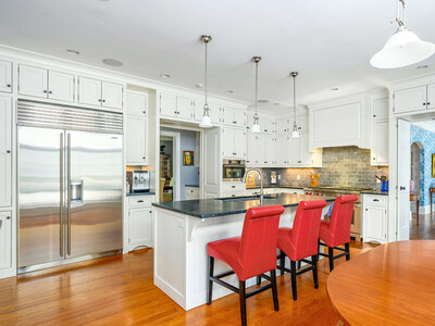 The gourmet kitchen includes a Sub-Zero refrigerator, 6-burner gas range by Wolf, Miele microwave, breakfast nook, and large center island countertop seating. Adjacent to the kitchen are a butler’s pantry and formal dining room (not pictured). VirginiaLuxuryAuction.com.