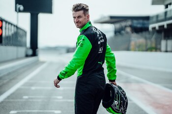 Nico Hulkenberg, Admin By Request ambassador, pictured ahead of the 2025 season in his race suit with helmet in hand.