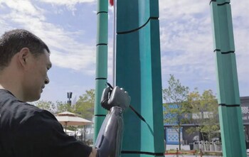 Ni demonstrates calligraphy on a bamboo installatio