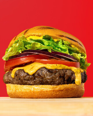 A classic cheeseburger stacked with fresh lettuce, tomato, onion, melted cheddar and mustard on a toasted bun; Photo Credit: Ingredient