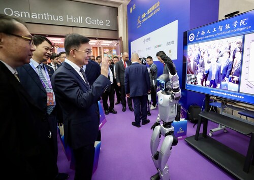 Participants interact with a humanoid robot at the 22nd China-ASEAN Expo. (PRNewsfoto/China Daily)