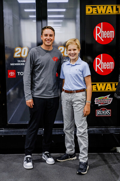St. Jude patient Cameron stands with driver Christopher Bell who drives the #20 DEWALT car.