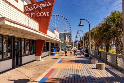 Visitors stroll along the famed Myrtle Beach Boardwalk in Myrtle Beach, SC, shopping for souvenirs, enjoying ocean views and soaking up the relaxing coastal atmosphere. Credit: Visit Myrtle Beach