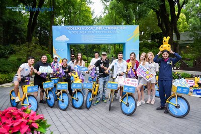 Expats and cycling enthusiasts gather for a group photo at Fudeli Park during the 