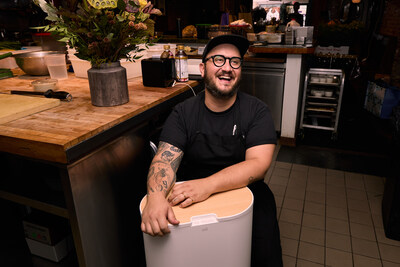 Fidel Caballero, Head Chef of Corima, with a Mill food recycler in the Corima kitchen for Mill's Make Food Not Waste Restaurant Week.
