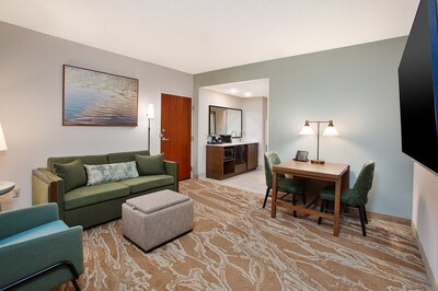 The refreshed two-room suites feature spacious living areas with modern furnishings and natural design accents.