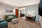 The refreshed two-room suites feature spacious living areas with modern furnishings and natural design accents.