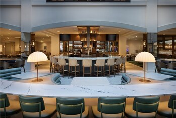 The transformed bar and lounge offer an inviting setting for dining, cocktails, and connection in the heart of the atrium.