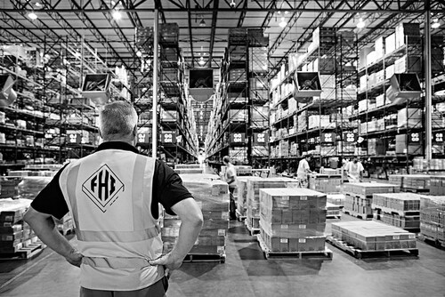 An FHI leader oversees warehouse operations inside a high-volume distribution center, where disciplined processes, lean management, and teamwork keep supply chains moving efficiently.