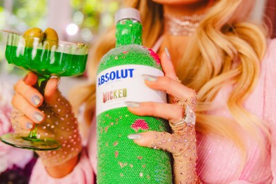 Paris Hilton poses with limited-edition Absolut Wicked: For Good themed sequin bottle sleeve.