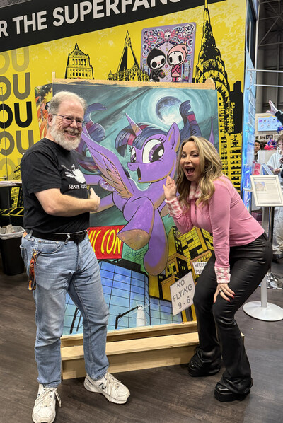 MY LITTLE PONY lead comic illustrator, Andy Price, and Tara Strong, voice of MY LITTLE PONY's Twilight Sparkle, pose by a giant, 4-by-6-foot hand-painted Twilight Sparkle Kayou card. The artwork was created live onsite by Price in just eight hours and will be reproduced as a future collectible card.