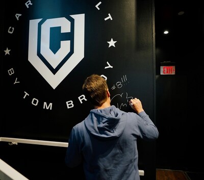 Tom Brady signs the wall at the new CardVault by Tom Brady store at American Airlines Center in Dallas - marking the 8th store which officially opens on October 23, 2025. Photo credit: CardVault by Tom Brady (PRNewsfoto/CardVault by Tom Brady)