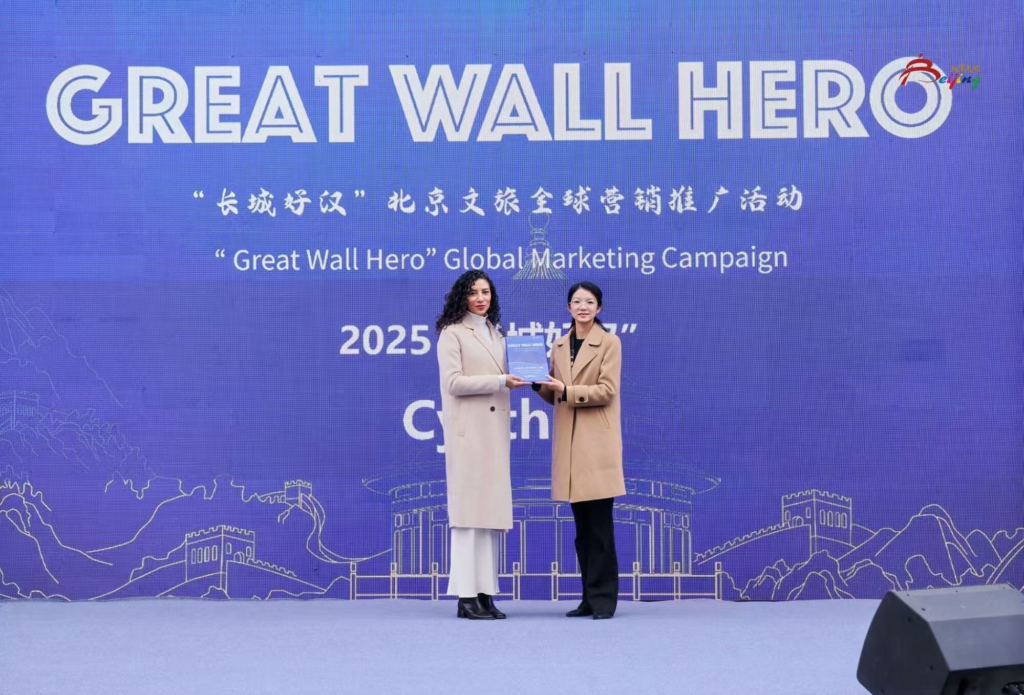 Ms. Zheng Fang, Deputy Director of the Beijing Municipal Bureau of Culture and Tourism, presents the award to a Great Wall Hero 2025 honoree.