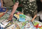 Parent and young child volunteering to sort books at literacy organization