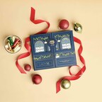 Top down view of Lady M's Holiday Crepe Biscuit Tasting Set on a beige background with red ribbon and ornaments.