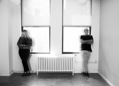 Black and white photo of The 456 duo (David Wolfert and Natasha Alexandra) standing apart by two windows, with a subtle double-exposure effect conveying separation.