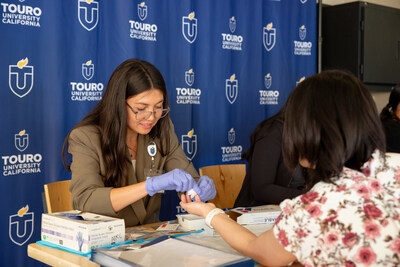 Student doctor Morgan Panitchpakdi conducts diabetes screening at MOBEC launch.