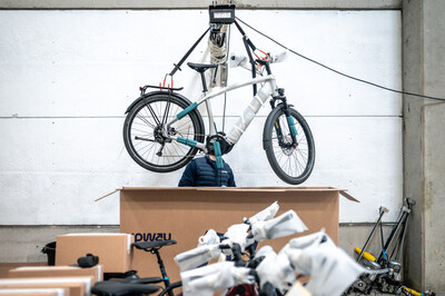A refurbished e-bike being lifted and prepared for packaging inside an Upway UpCenter, where mechanics inspect and ready bikes for shipment. A refurbished e-bike being lifted and prepared for packaging inside an Upway UpCenter, where mechanics inspect and ready bikes for shipment.