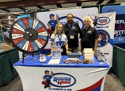 Rooter Hero Plumbing & Air booth at the Northern California Facilities Expo. Pictured left to right are Allie Lavoie, Peter Inunza, and Troy Thomas. They stand smiling behind the Rooter Hero display table, which features a prize wheel offering candy, mini flashlights, and a chance to win a free safety plumbing inspection. Rooter Hero Plumbing & Air booth at the Northern California Facilities Expo. Pictured left to right are Allie Lavoie, Peter Inunza, and Troy Thomas. They stand smiling behind the Rooter Hero display table, which features a prize wheel offering candy, mini flashlights, and a chance to win a free safety plumbing inspection.