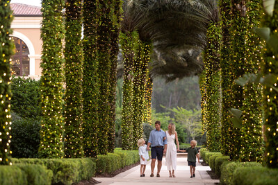 Stroll beneath the palm pathway wrapped in twinkling holiday lights. Stroll beneath the palm pathway wrapped in twinkling holiday lights.