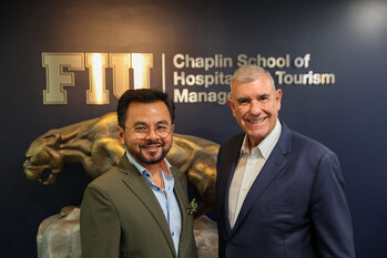 Michael Cheng (left), Florida International University (FIU) Chaplin School dean, welcomes cruise industry icon Larry Pimentel (right) to lead groundbreaking hospitality initiatives at top-ranked program in Miami. (FIU Chaplin School Photo/Ivonne Yee-Amor)   (Image at LateCruiseNews.com - November 2025)