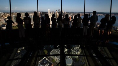 Guests enjoy the view at Space Needle's Loupe, the world's only rotating glass floor.