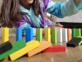 Child playing with colorful dominoes